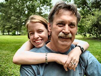 Daughter hugging her Father  in the park.